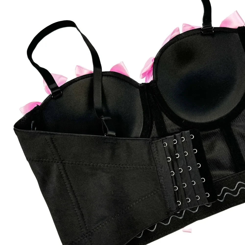 Black lace-up bra with pink accents on a white background
