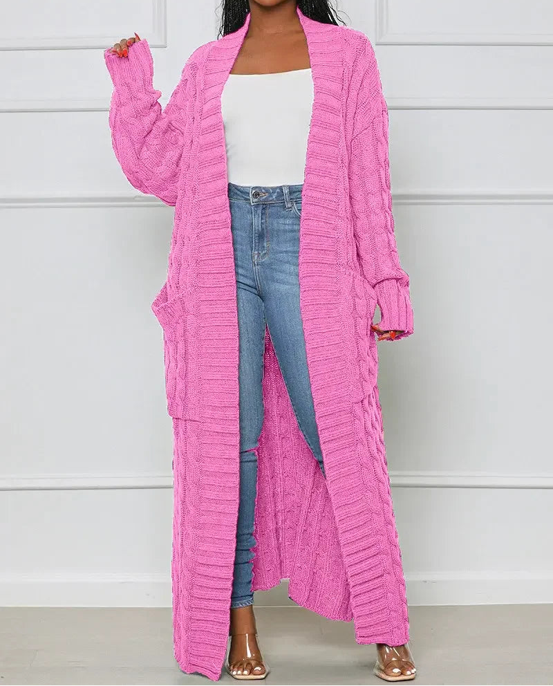 Person wearing a pink ribbed cardigan over a white top and blue jeans