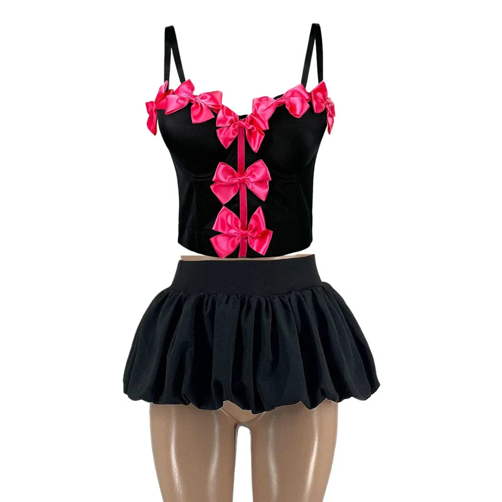Black outfit with pink bows on a white background
